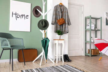 Stylish interior of modern hall with umbrellas and clothes hanger