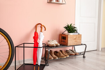 Stylish interior of modern hall with umbrellas and shoes