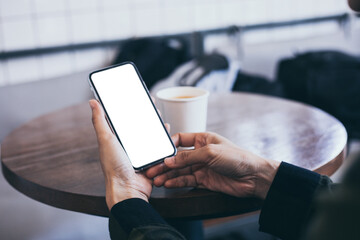 cell phone mockup image blank white screen.woman hand holding texting using mobile on desk at coffee shop.background empty space for advertise.work people contact marketing business,technology