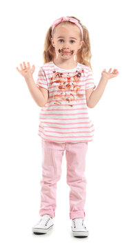 Little girl with chocolate stains on her clothes against white background