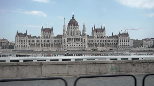 Tracking the parliament building from a public tram along the Danube River Budapest Hungary