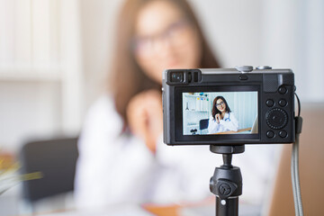 Close up camera video recording live stream communication interacting with online patients by Asian female doctor using laptop computer, working in hospital modern office, medical healthcare clinic