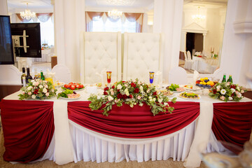 Decor of a wedding party. Wedding table decoration in a restaurant. Glasses, drinks, food. Festive decoration of the interior.