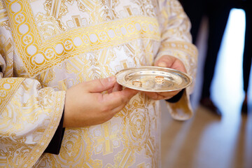 Wedding of the bride and groom. The priest holds in his hands a gold plate with wedding rings....