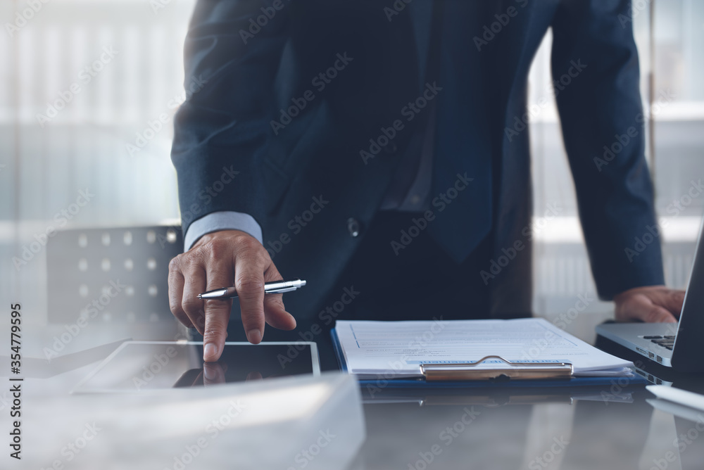 Wall mural Businessman manager working on digital tablet and laptop computer in office