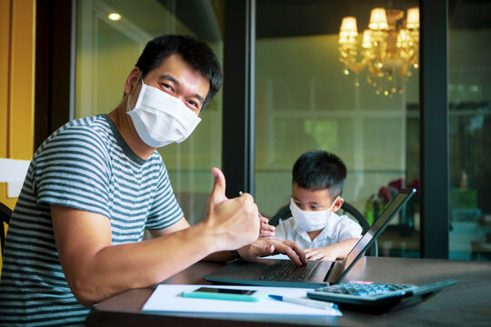 quarantine asian man and children wearing protection mask working on computer at home selected focusing on children face