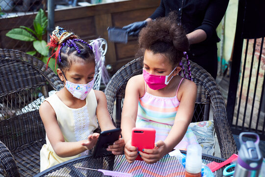 Young Mixed Race Girls Having Their Hair Braided
