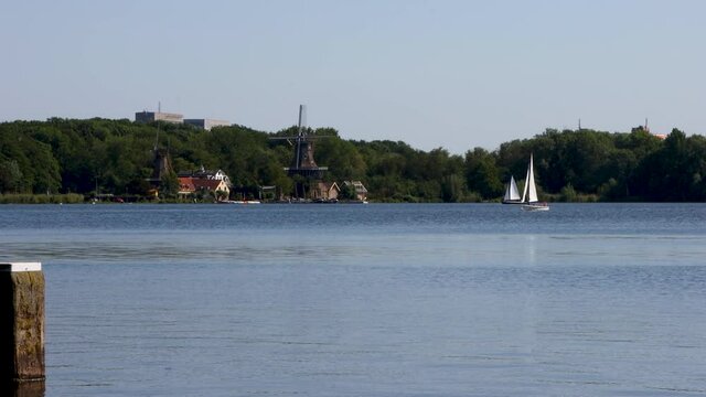 The Netherlands Kralingse Plas with sailboat, ducks and traditional old dutch Windmill