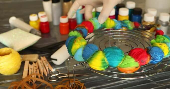 Woman applying tie dye technique to t shirt