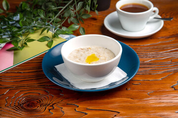 Oatmeal with butter and coffee for breakfast at home