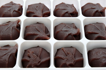 Japanese Ankoro Mochi, a Japanese rice cake made with red bean paste, in white packaging - closeup angled view.