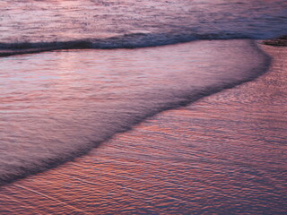 Abstract landscape reflection of a pink sunset on waves