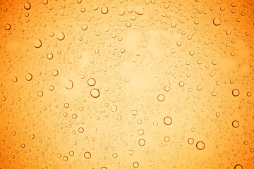 Rain droplets on yellow glass background, Water drops on yellow glass.