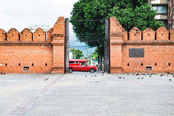Thailand - June 19, 2019 : Tha Phae Gate and Old Wreckage Wall with Chiang Mai Local Red Cab Taxi...