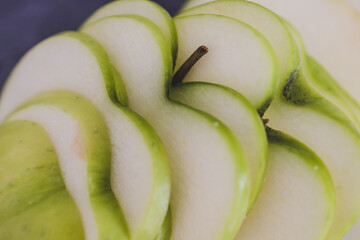 food ingredients concept, green apple cut into thin equal slices with a heart shape