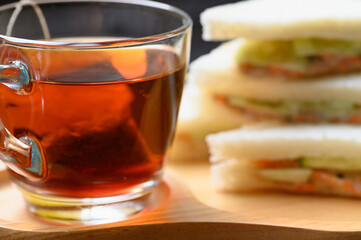 Hot Tea with Tuna Sandwich on wooden plate