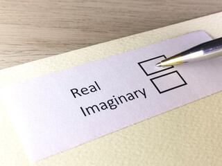 One person is answering question on a piece of paper. The person is thinking to be real or imaginary.