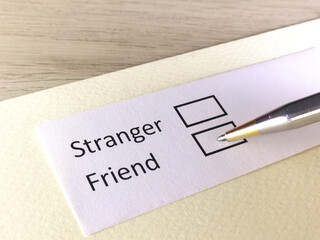 One person is answering question on a piece of paper. The person is thinking to be stranger or to be friend.