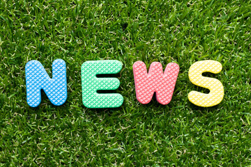 Toy foam letter in word news on green grass background