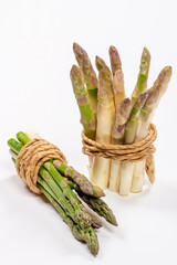 Green and white fresh asparagus on a gray background