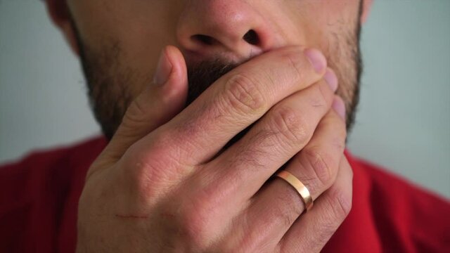 Caucasian man wipes his beard, close angle
