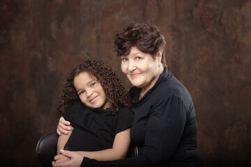 Portrait of happy grandmother with granddaughter indoors.