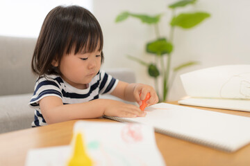 リビングでお絵かきしている3歳の女の子