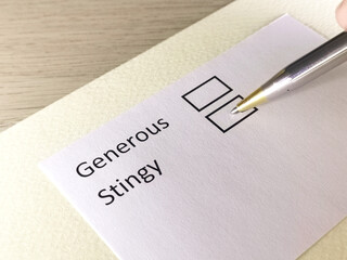 One person is answering question on a piece of paper. The person is thinking to choose stingy or generous.