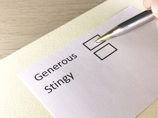 One person is answering question on a piece of paper. The person is thinking to choose stingy or generous.