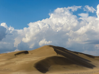 Great sand dune surrounded by clouds at sunset