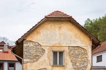 Old house with peeling stucco and bare stones