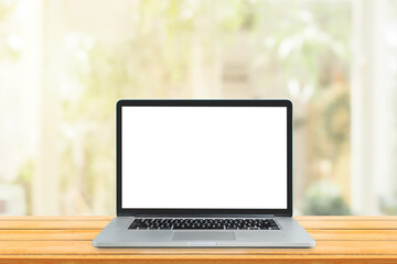 Work from Home and Business Communication Concept : Used laptop with blank white screen on wooden table and blurry image of Living room in background.