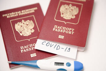Coronavirus Quarantine and travel concept. Passport with COVID-19 inscription. Coronavirus COVID-19 pandemic. Fever, coronavirus symptoms and travel.
