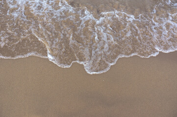 Fototapeta na wymiar Sea surf, waves rolls on a sandy beach