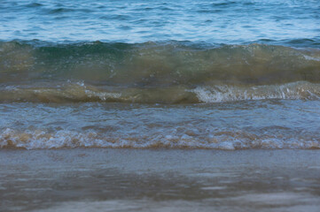 Sea surf, waves rolls on a sandy beach