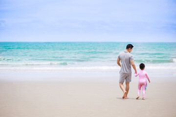 Fototapeta na wymiar Happy family. Happy vacation holiday. Father and daughter walking and holding hands on the beach together in summer. Relaxation in vacation in the summer concept.