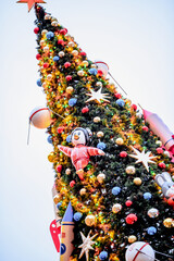 2019, December  8. Christmas tree with balls and garlands on the alley with a large Christmas tree with toys and people, Moscow, red square winter. Christmas tree decorated with  balls and space toys.