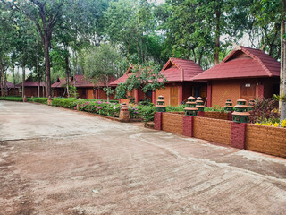 The row of cubicle or guesthouse made by red brick among abundance forest. 