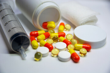 Capsules, cotton buds and dosage tubes placed near a white medicine bottle