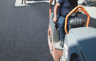 Worker driving asphalt machine. Road construction