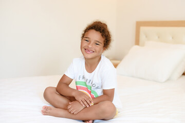 Cute little girl in pajamas on the bed in the morning.