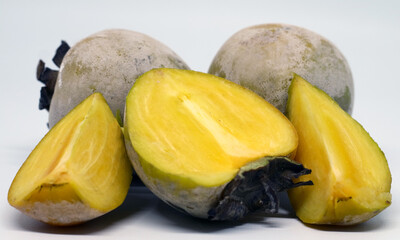 Persimmon or kesemek on white background. The fruit is covered by white flour after immersing in water with calcium oxide to remove tannin.
