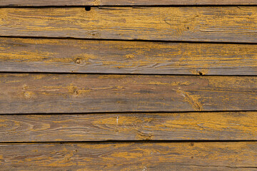 Texture of a yellow fence made of wooden boards