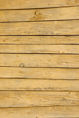 Texture of a yellow fence made of wooden boards