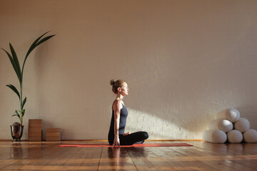 Woman sitting in lotus position meditating - 354814348