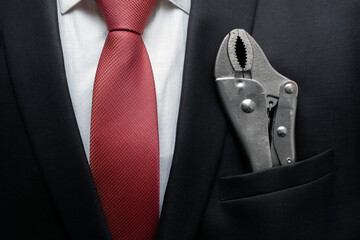 Businessman with locking pliers or vise grips in suit pocket. Business creation concept. Auto repair business concept. Appliance repair business.