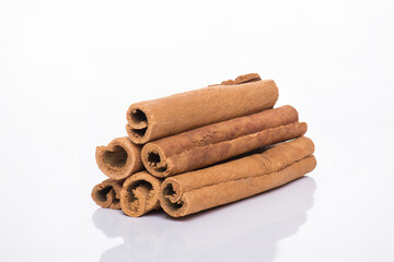 Close-up photo of a stack of cinnamon sticks isolated on white background
