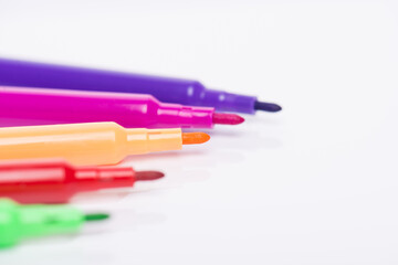 Multicolored markers concept. Close-up cropped photo of markers with no caps isolated on white background