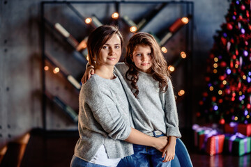 Mother and Child Hug in Front of a Christmas Tree.