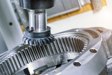 A modern CNC milling machine makes a large gear wheel.